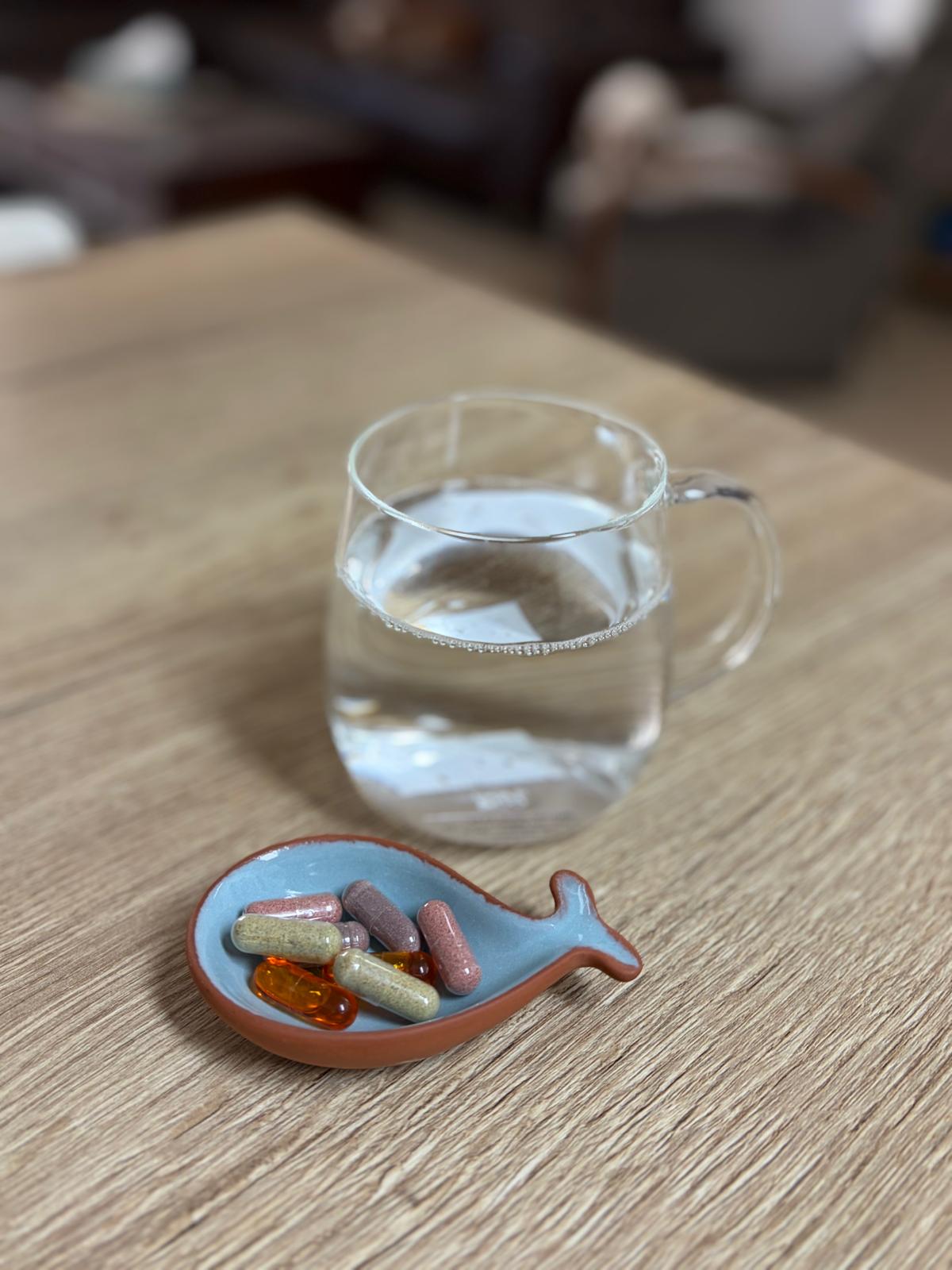הרגל יומי — קפסולות עם כוס מים
